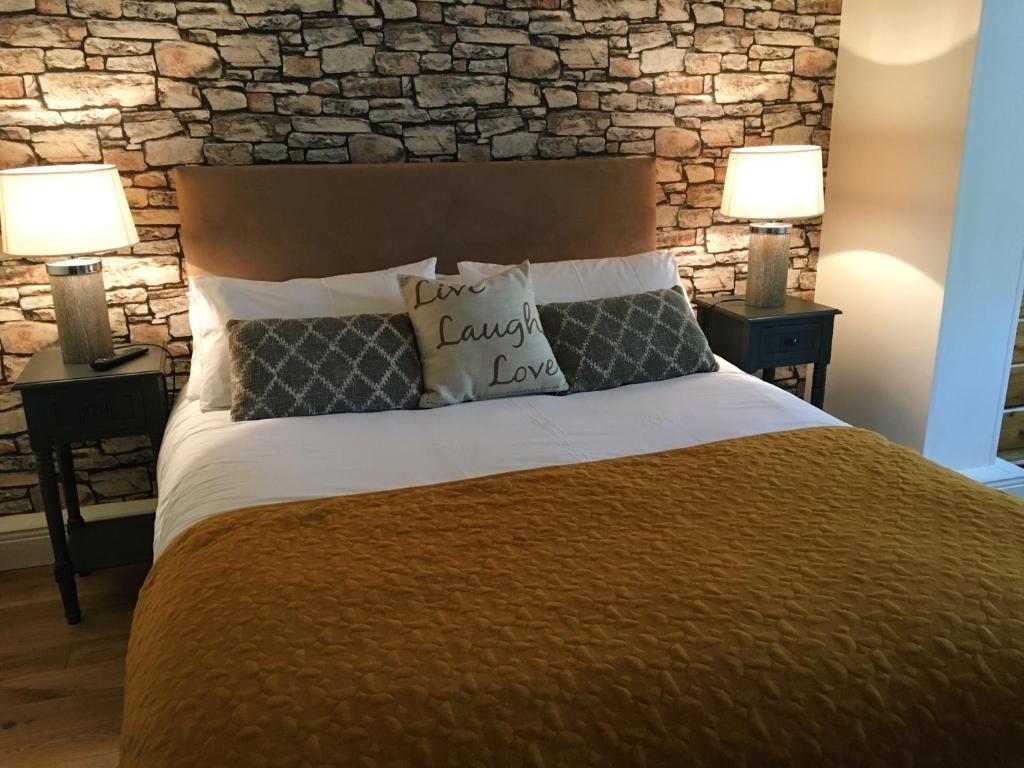 a bedroom with a large bed with two lamps at Abbeyvilla Guesthouse Room Only in Adare