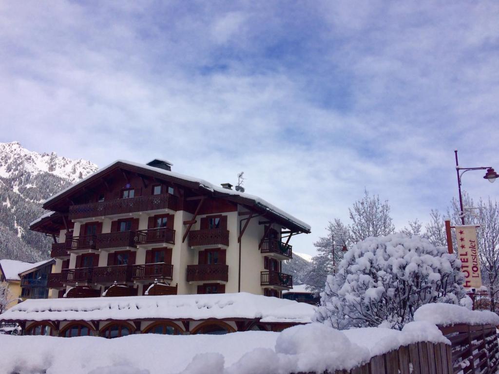 a snow covered apartment building with a snow covered roof at Oustalet in Chamonix