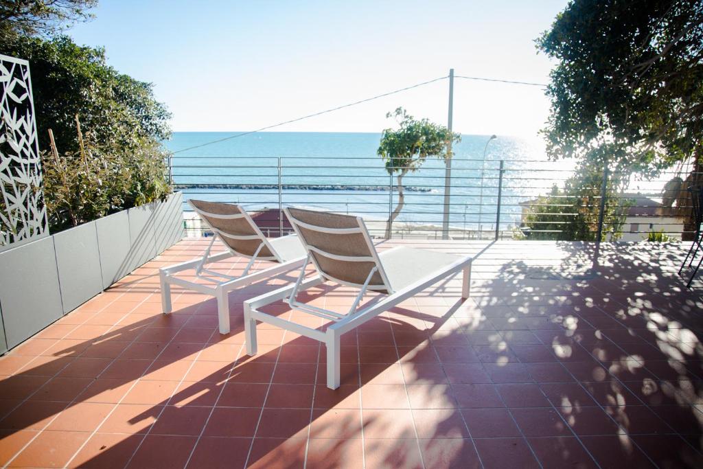 2 stoelen op een balkon met uitzicht op de oceaan bij Terramata Resort Case Vacanza in Santo Stefano al Mare