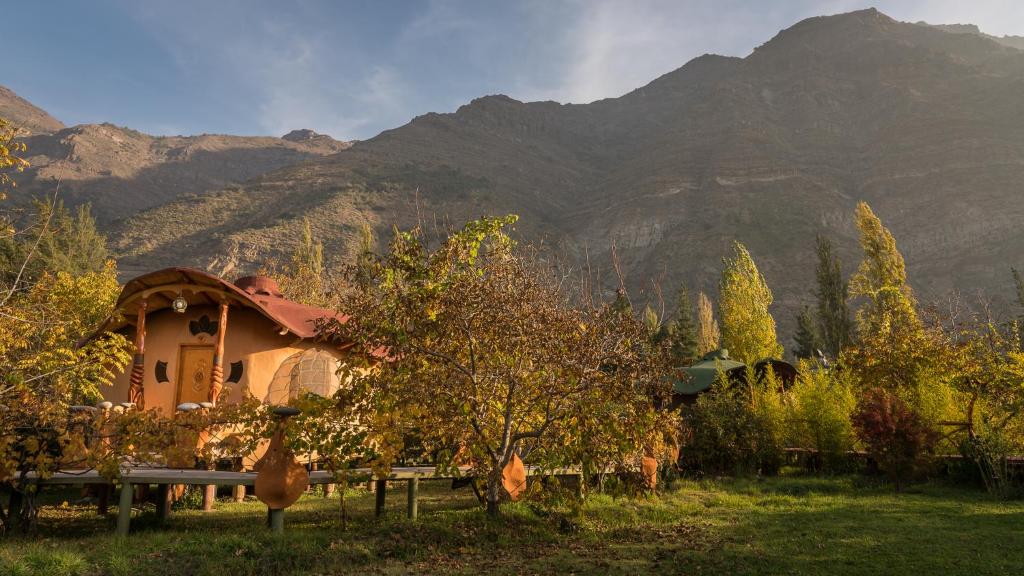 una casa in un campo con montagne sullo sfondo di Cascada Lodge Cajon del Maipo a San José de Maipo