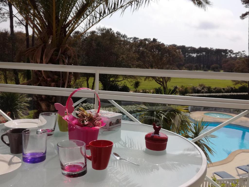 a white table with glasses and flowers on a balcony at Location d Armelle - Moliets in Moliets-et-Maa