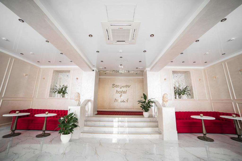 a lobby with a red bench and a stage at Sergeev Hotel in Mykolaiv