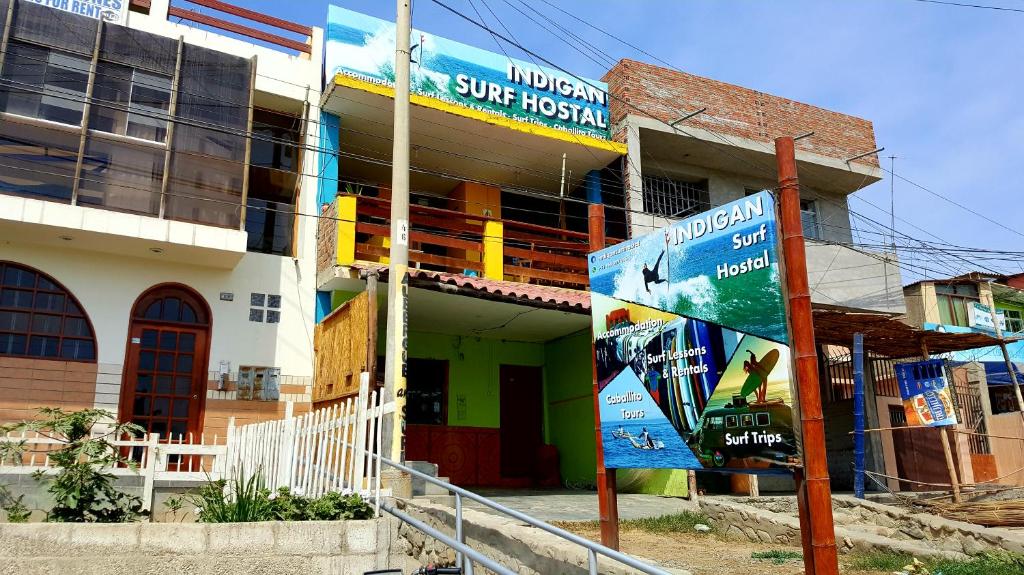 a building with a sign in front of it at Urcia Surf House in Huanchaco