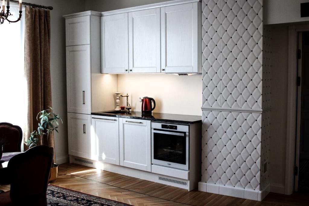 a kitchen with white cabinets and a stove at Posti Apartment in Haapsalu