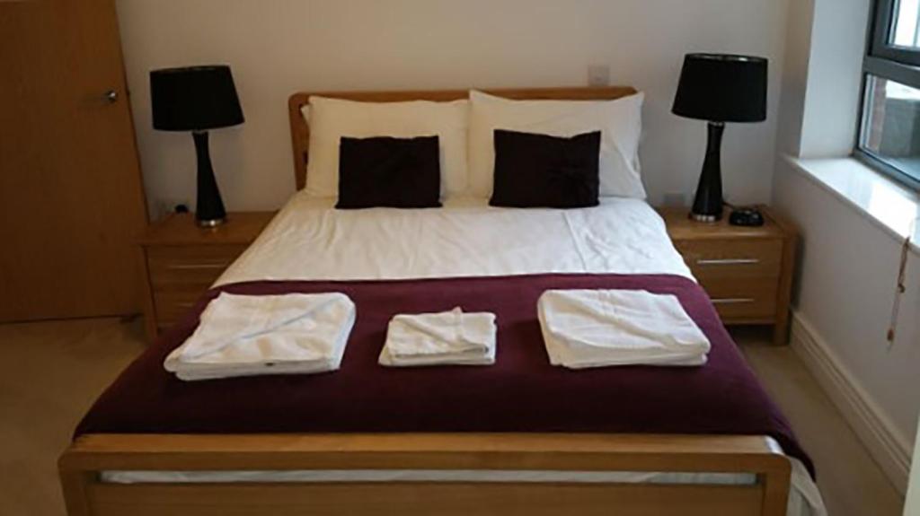 ein Schlafzimmer mit einem Bett mit zwei Handtüchern darauf in der Unterkunft Oxford Apartment Central - Jericho Riverfront--Free parking -2 bedrooms- 2 bathrooms - Easy walk to Bus and Rail station in Oxford