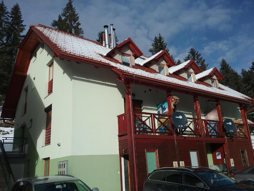 a building with a red roof and a balcony at Hudinja 111 in Vitanje