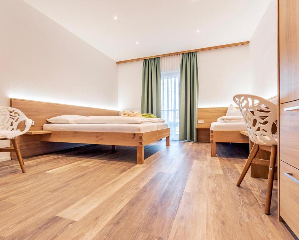 1 Schlafzimmer mit 2 Betten und 2 Stühlen in der Unterkunft Flöckner B&B in Salzburg
