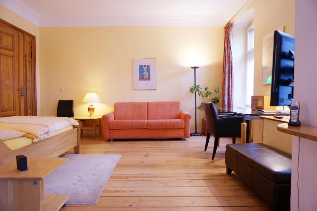 a hotel room with a bedroom with a bed and a couch at EigenArt Appartement in Berlin