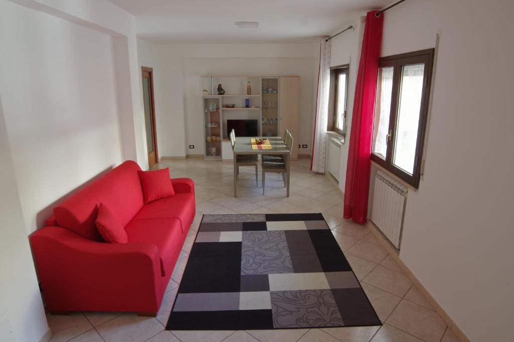 - un salon avec un canapé rouge et une table dans l'établissement Cortile Fichi d'india, à Sciacca