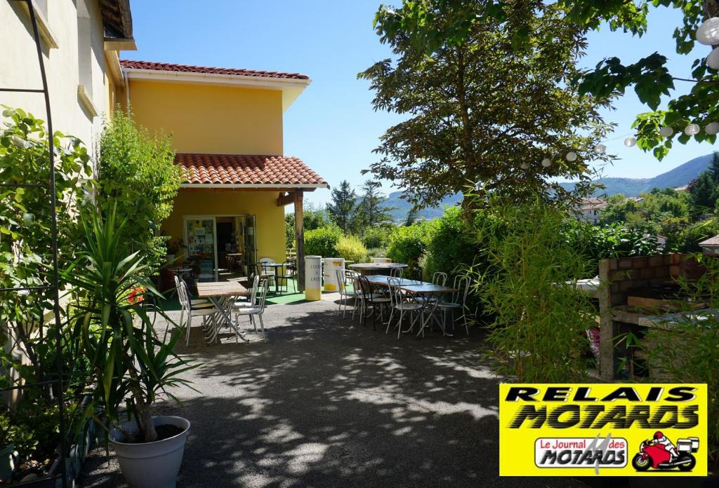 un patio de una casa con mesas y sillas en Gîte des Grands Causses en Millau