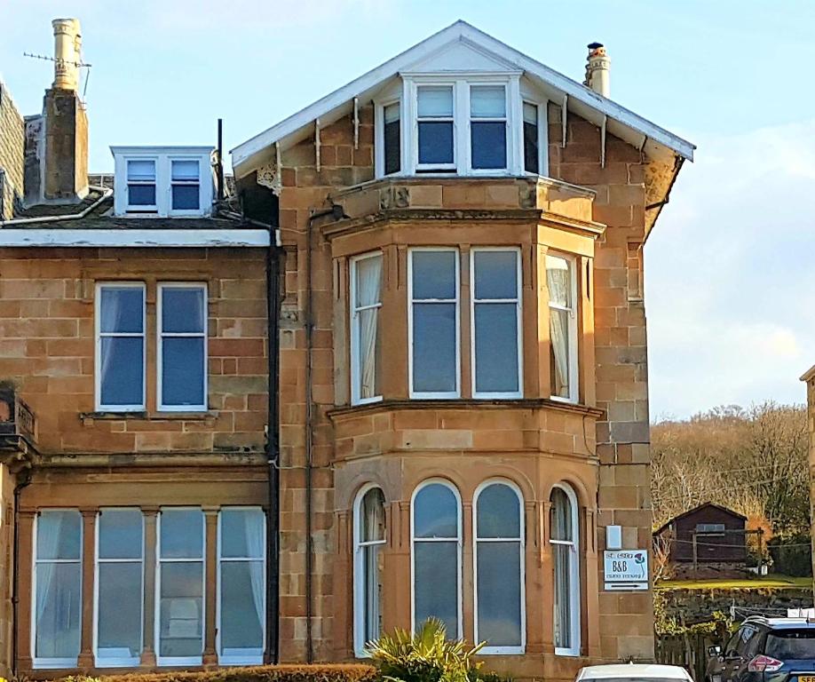 an old brick house with large windows on a street at St.Ebba B&B in Rothesay