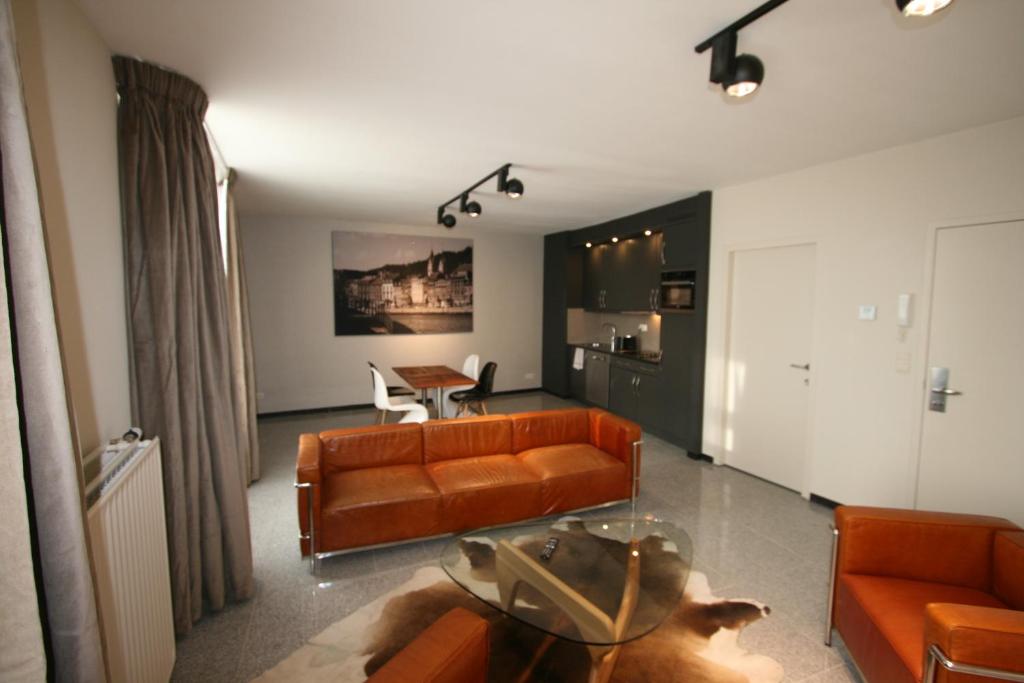 uma sala de estar com um sofá e uma mesa em Amosa Liège City Centre Apart Regence 17 em Liège
