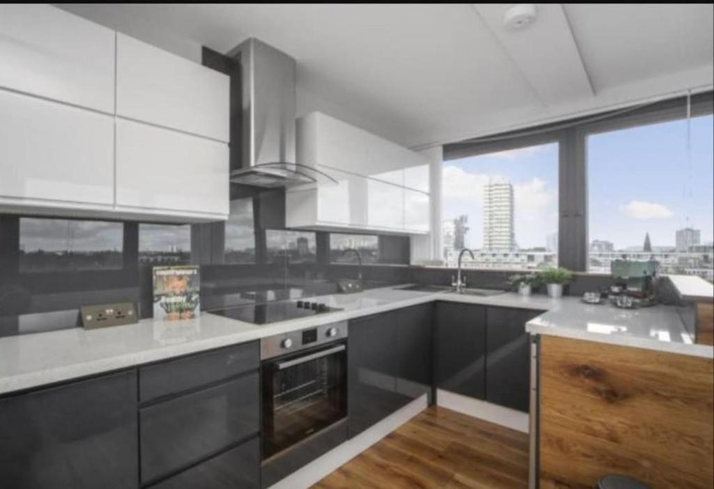 una cocina con electrodomésticos y ventanas en blanco y negro en Incredible 3BR Battersea Flat & Spectacular View, en Londres