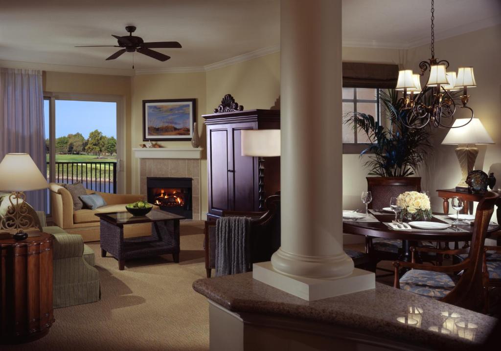 a living room with a fireplace and a dining room at Marina Inn at Grande Dunes in Myrtle Beach
