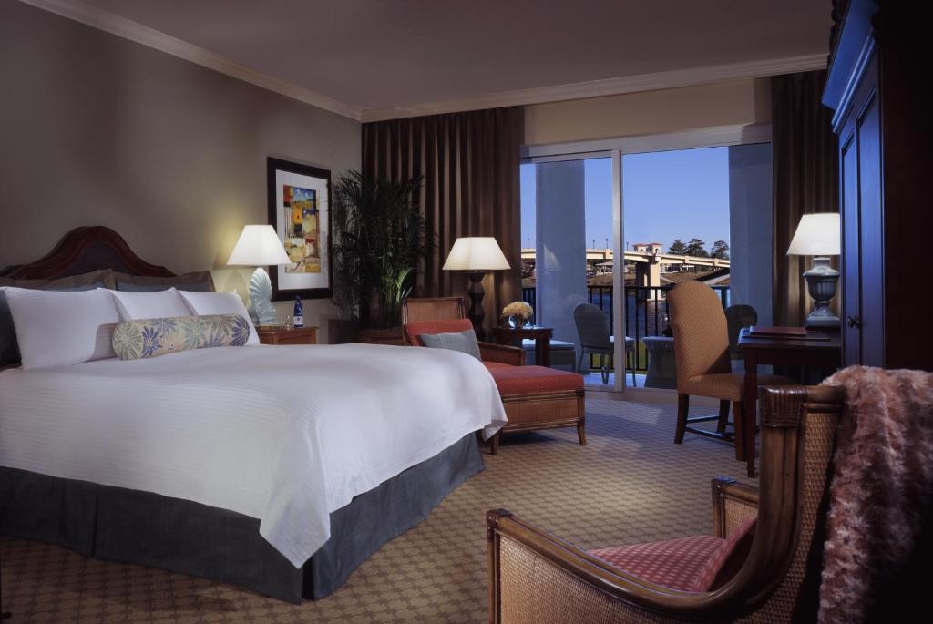 a hotel room with a large bed and a balcony at Marina Inn at Grande Dunes in Myrtle Beach