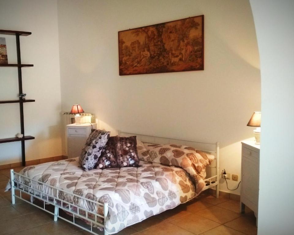 una camera da letto con un letto e un dipinto sul muro di La piazzetta a Pignola