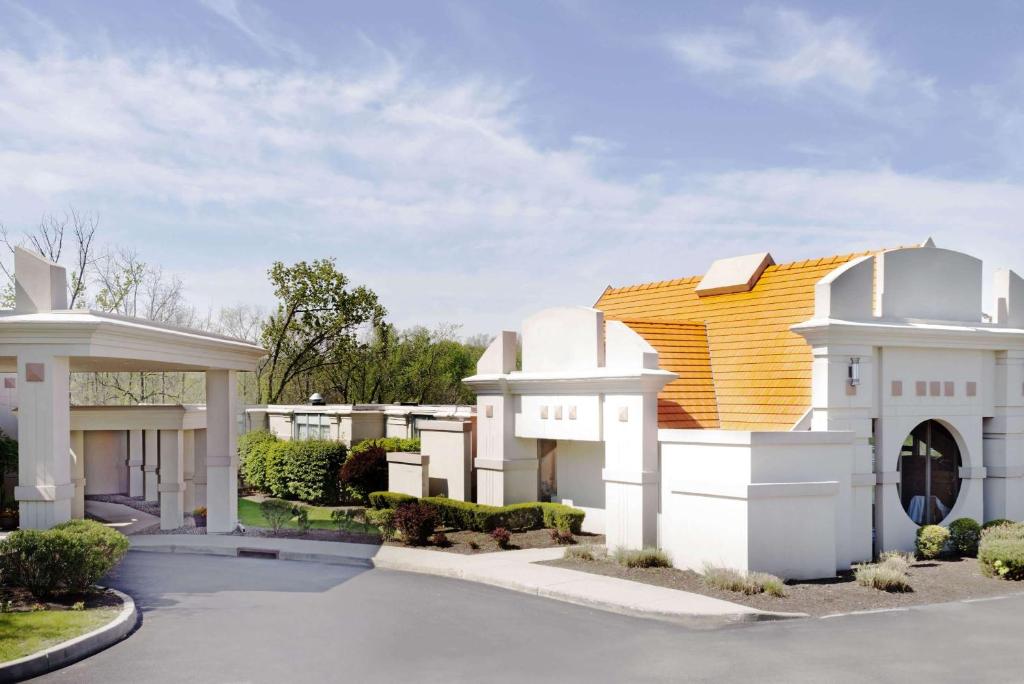 a large white house with a yellow roof at Howard Johnson by Wyndham Newburgh in Newburgh