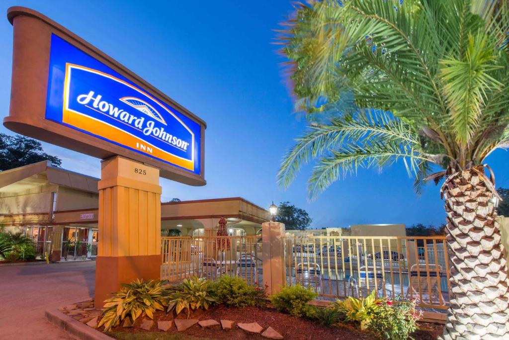 a sign in front of a shopping center with a palm tree at Howard Johnson by Wyndham Historic Lake Charles in Lake Charles
