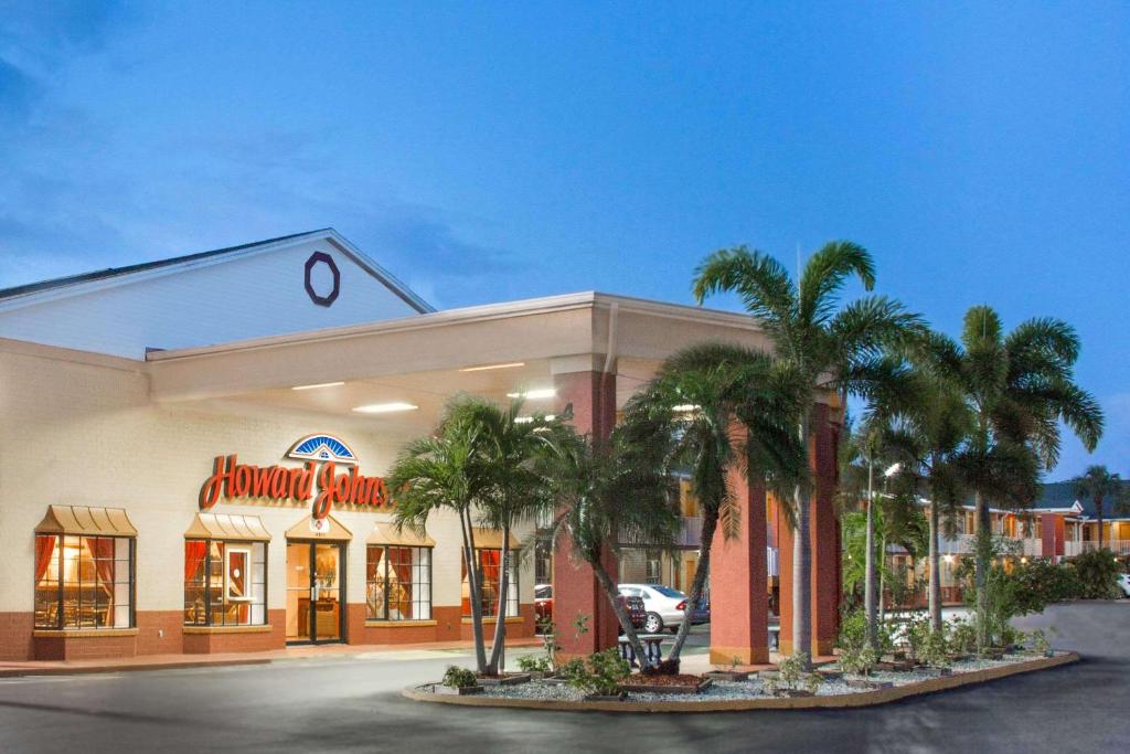 ein Lebensmittelgeschäft mit Palmen davor in der Unterkunft Howard Johnson by Wyndham Ft. Myers FL in Fort Myers