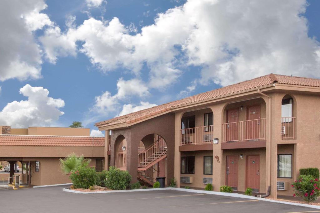 a building with a parking lot in front of it at Howard Johnson by Wyndham St. George Hotel & Suites in St. George
