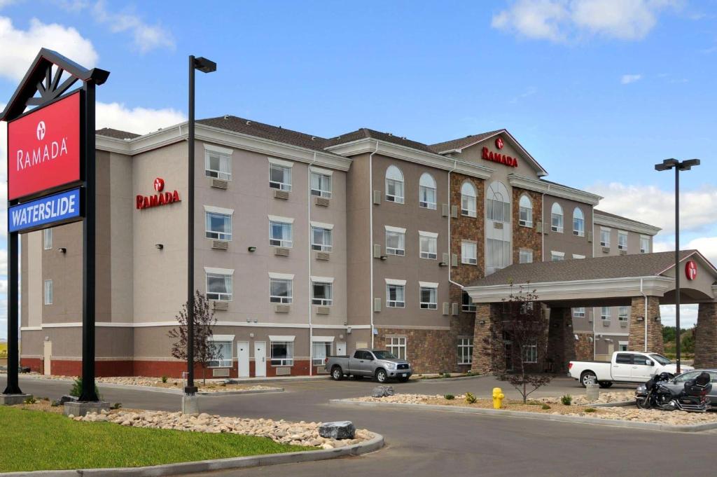 a hotel with a sign in front of a building at Ramada by Wyndham Wainwright in Wainwright