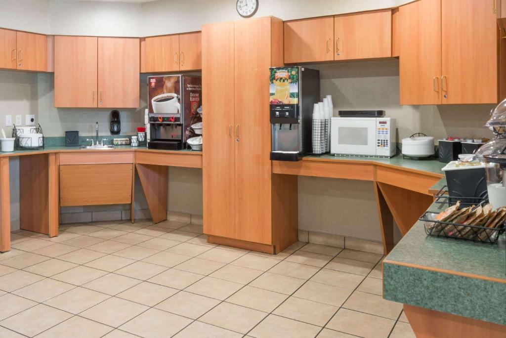 eine große Küche mit Holzschränken und -geräten in der Unterkunft Microtel Inn &amp; Suites by Wyndham Uncasville Casino Area in Uncasville
