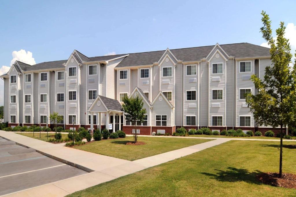 duży biały budynek z trawnikiem przed nim w obiekcie Microtel Inn & Suites Huntsville w mieście Huntsville