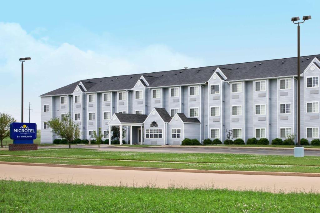 a large white building with a sign in front of it at Microtel Inn by Wyndham Champaign in Champaign