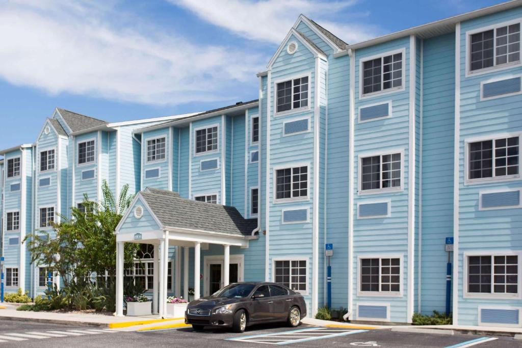 a car parked in front of a blue building at Microtel Inn & Suites by Wyndham Port Charlotte Punta Gorda in Port Charlotte