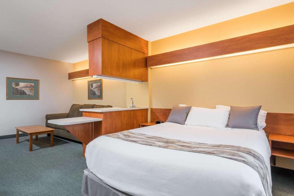 um quarto de hotel com uma cama grande e uma cozinha em Microtel Inn & Suites by Wyndham New Ulm em New Ulm