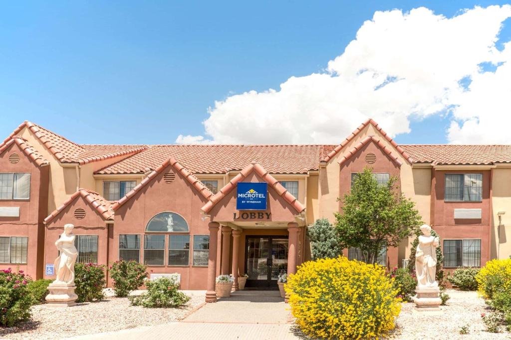 a building with two statues in front of it at Microtel Inn & Suites by Wyndham Gallup - PET FRIENDLY in Gallup