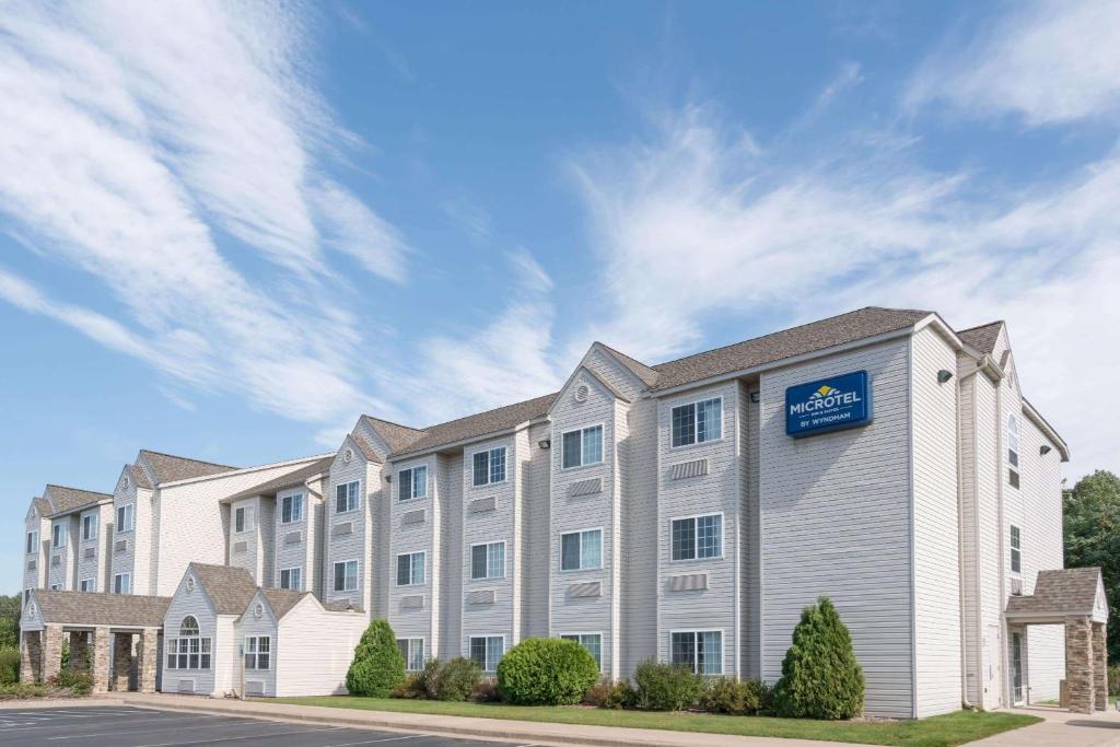 a building with a sign on the side of it at Microtel Inn & Suites by Wyndham Rice Lake in Rice Lake