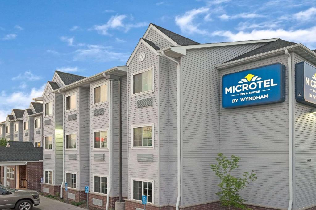 a building with a sign for a micro hotel at Microtel Inn and Suites - Inver Grove Heights in Inver Grove Heights