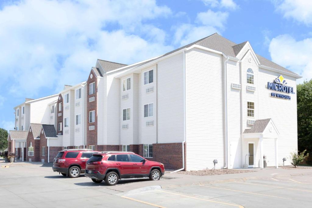 a red suv parked in front of a building at Microtel Inn & Suites - Kearney in Kearney