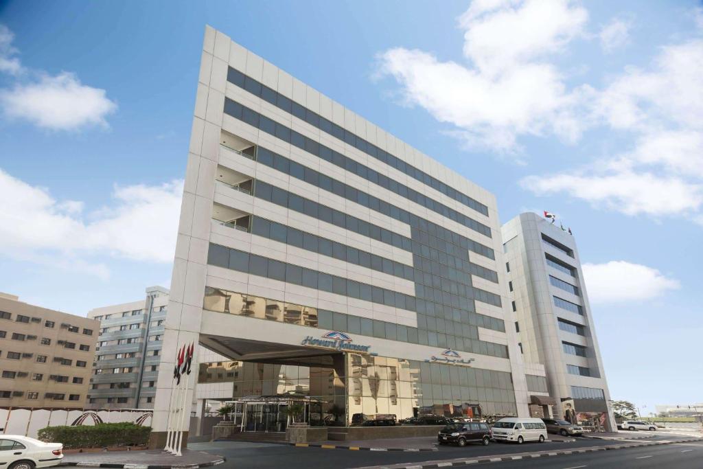 a large white building with cars parked in front of it at Howard Johnson Bur Dubai in Dubai