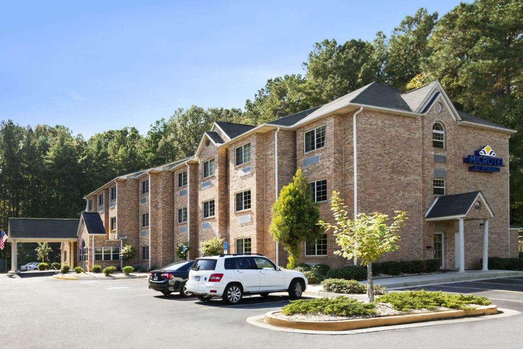 a large brick building with cars parked in a parking lot at Microtel Inn & Suites by Wyndham Lithonia/Stone Mountain in Lithonia