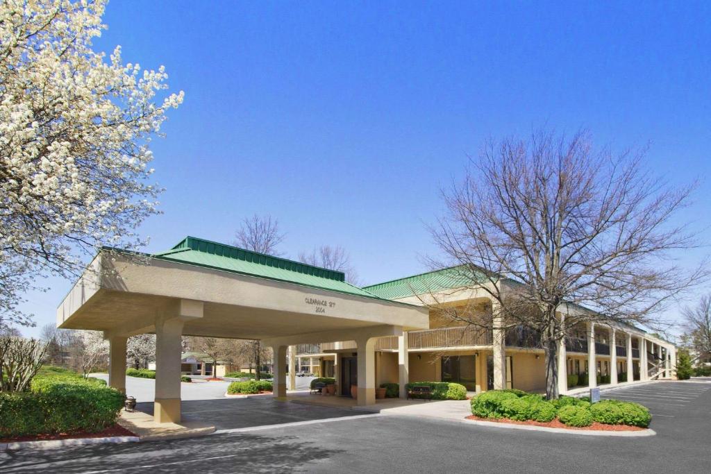a building with a parking lot in front of it at Howard Johnson by Wyndham Greensboro Near the Coliseum in Greensboro