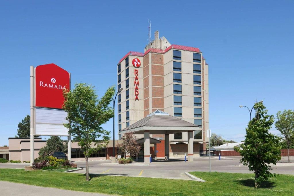 un bâtiment d'hôtel avec un kiosque devant lui dans l'établissement Ramada by Wyndham Lethbridge, à Lethbridge