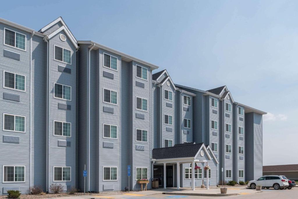 a large building with a car parked in front of it at Microtel Inn & Suites by Wyndham Stanley in Stanley
