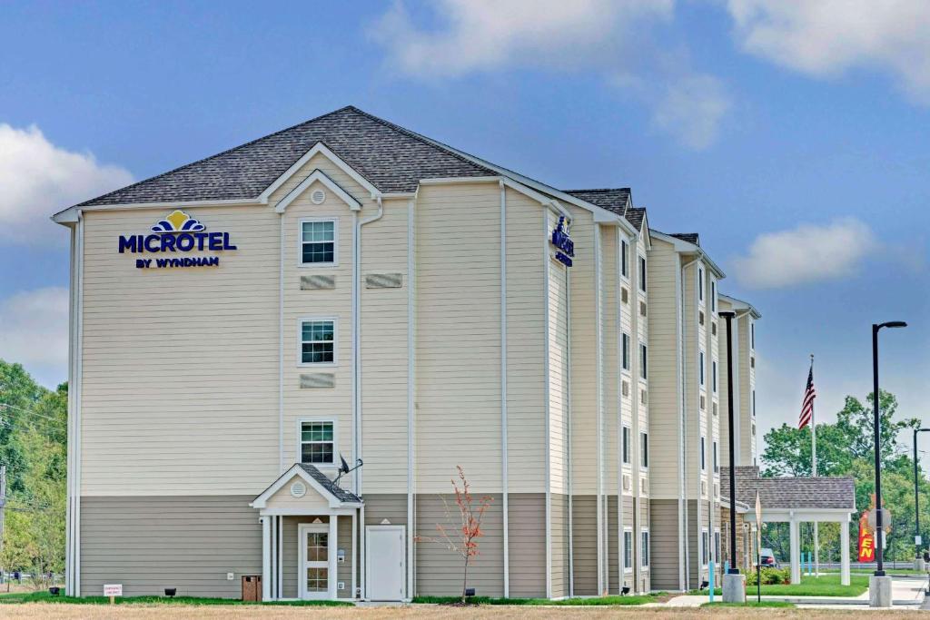 un gran edificio blanco con un cartel. en Microtel Inn & Suites by Wyndham Philadelphia Airport Ridley Park, en Ridley Park