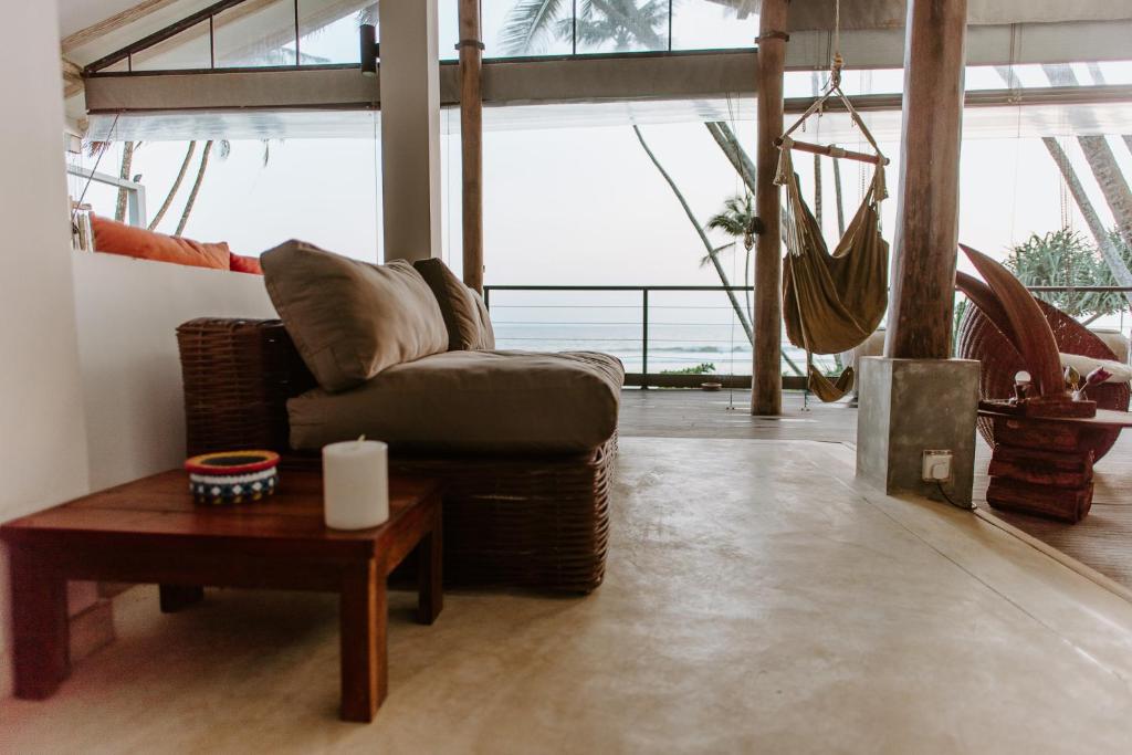 uma sala de estar com um sofá e uma mesa em Vanina Villas em Matara