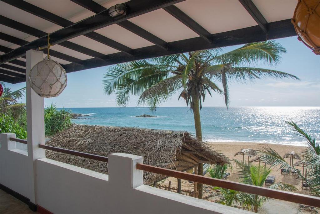 Blick auf den Strand vom Balkon eines Hauses in der Unterkunft Sailors' Bay in Hikkaduwa