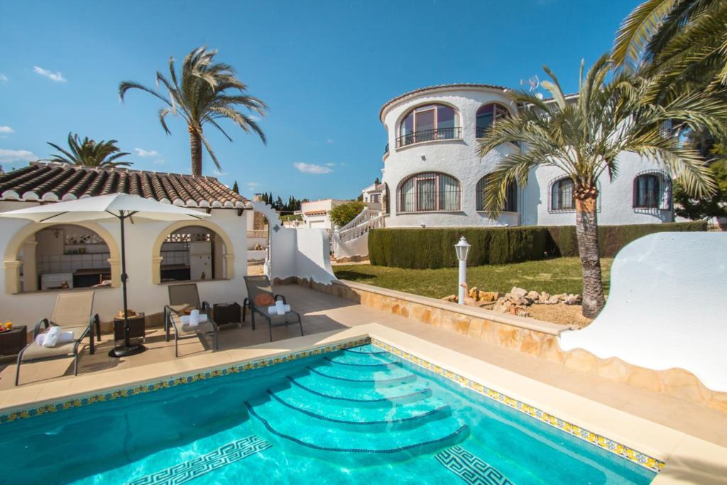 a villa with a swimming pool in front of a house at Apartment Villa Chloe in Calpe