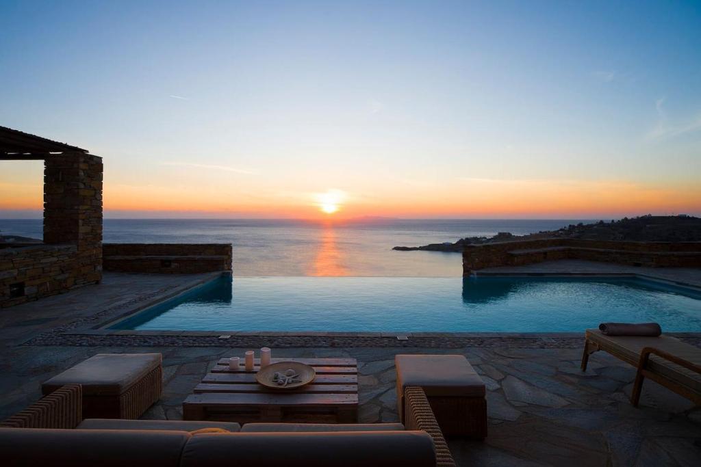 una piscina con puesta de sol en el fondo en Luxury Cycladic Villa-Enjoy Infinity Pool Sunsets, en Koundouros