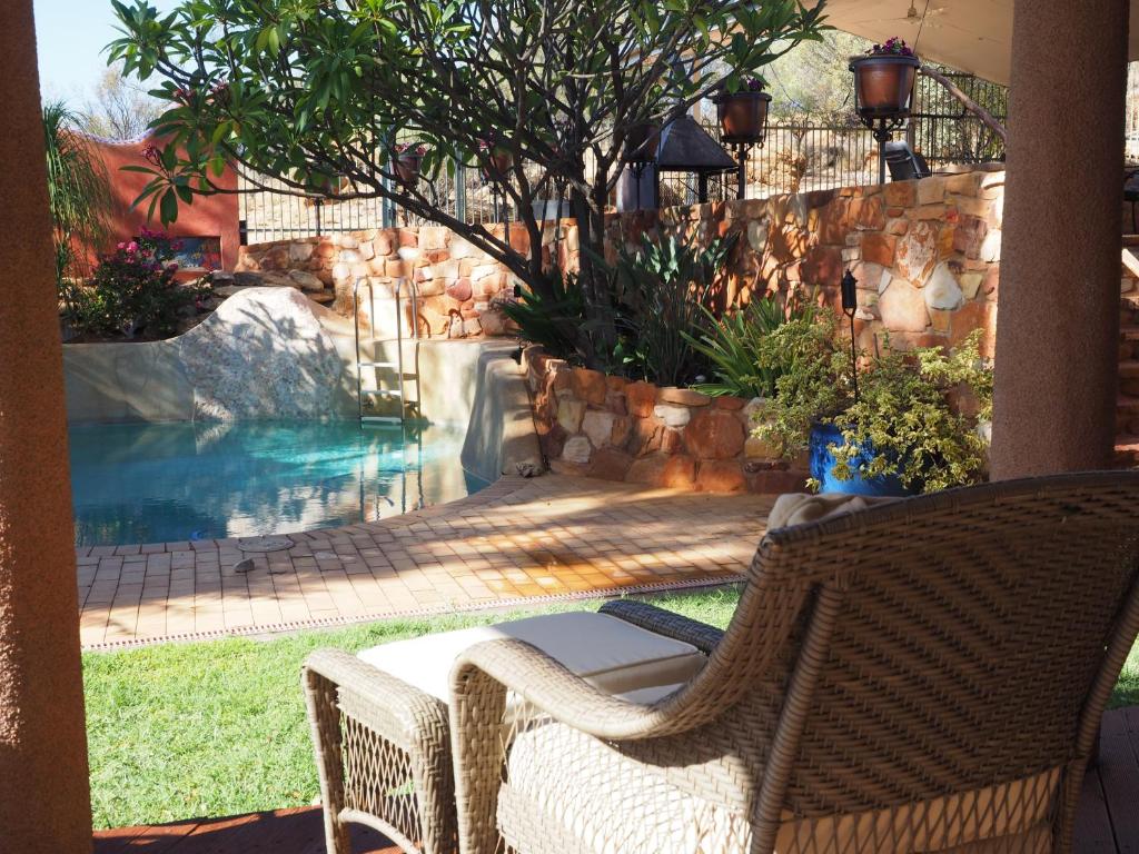 a backyard with a swimming pool and a waterfall at Wilmots on Dixon in Alice Springs