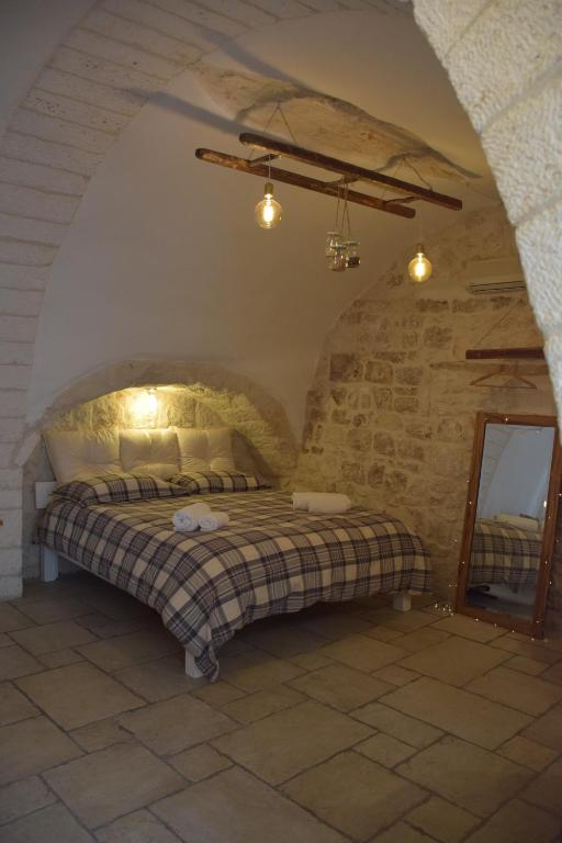 a bedroom with a bed in a stone wall at Dimora Levante in Ostuni