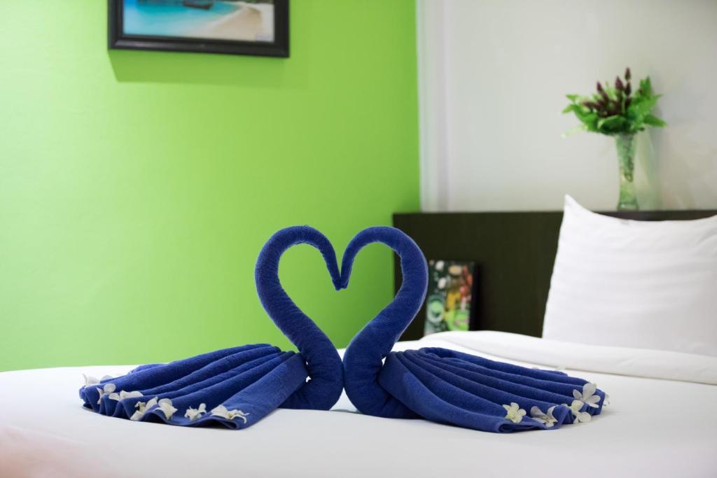 two blue towels in the shape of a heart on a bed at Colorize Boutique Hotel in Lamai