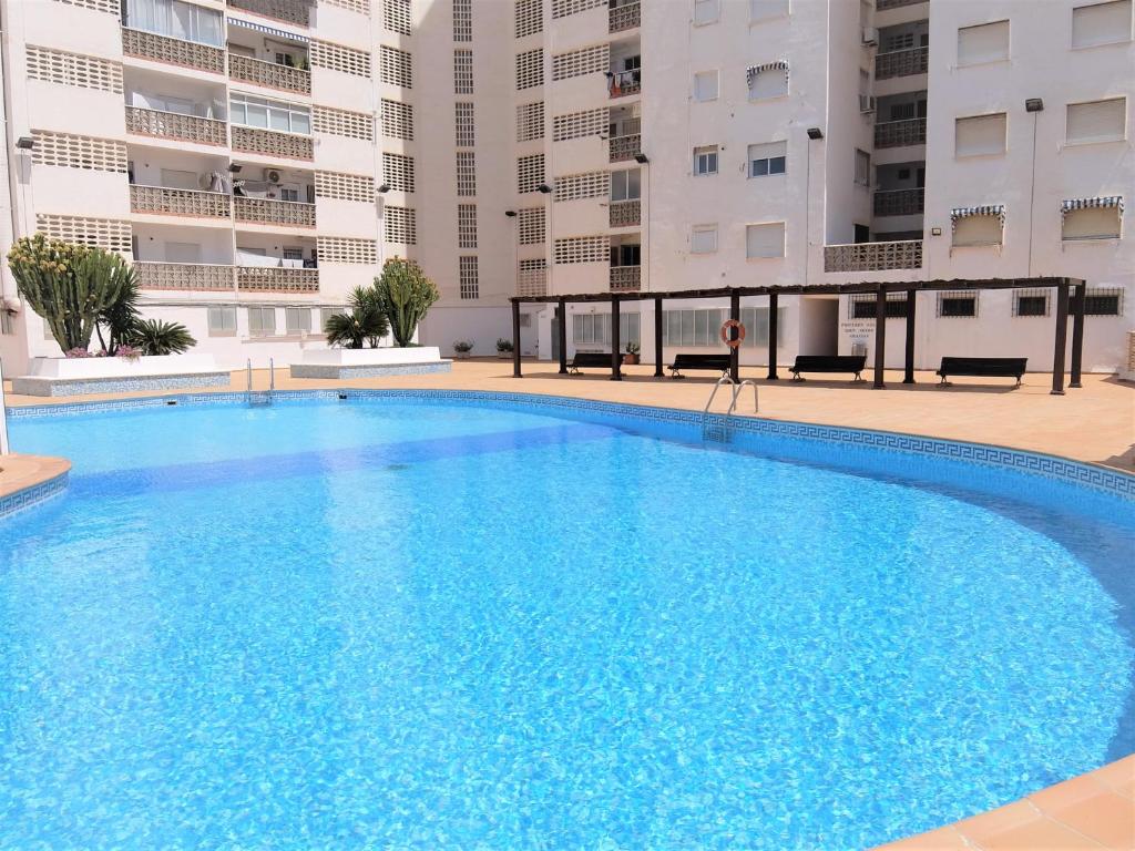 a large blue swimming pool in front of some buildings at BONAIRE - PRIMERA LÍNEA DE PLAYA in Playa de Gandia