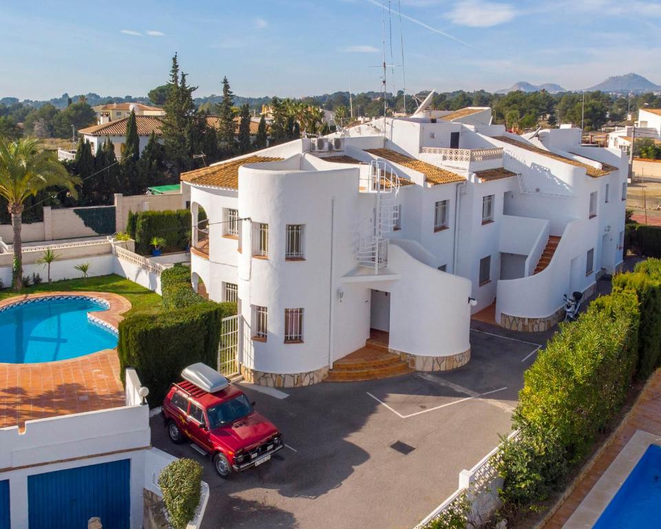 an aerial view of a large white house with a red truck at Ashanti Garden Luxury Short Term Rental Duplex Altea in La Nucía
