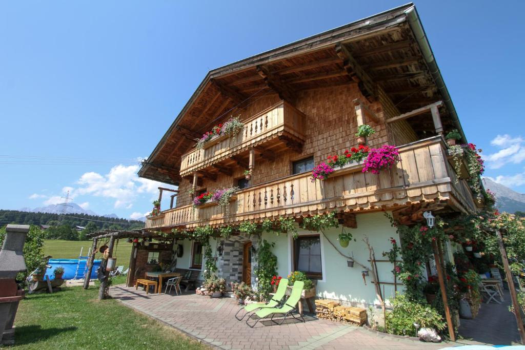 a building with a balcony and flowers on it at Appartment Eggerhof in Saalfelden am Steinernen Meer